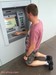 kneeling in front of the ATM